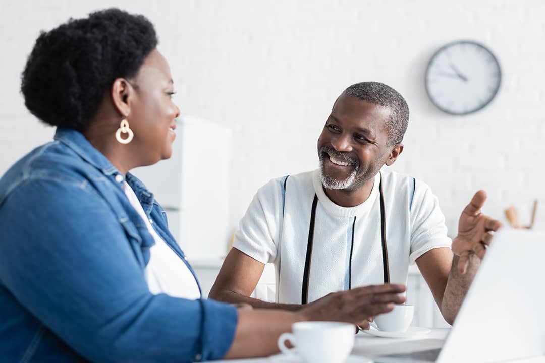 A black couple engaged in a healthy discussion at home.